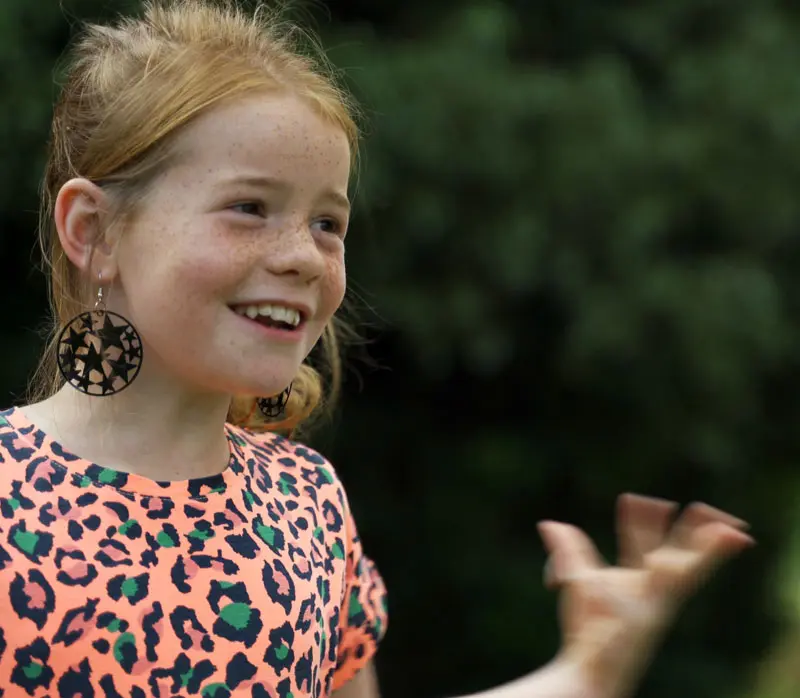 Kinderen zingen samen tijdens een zangles in de buitenlucht