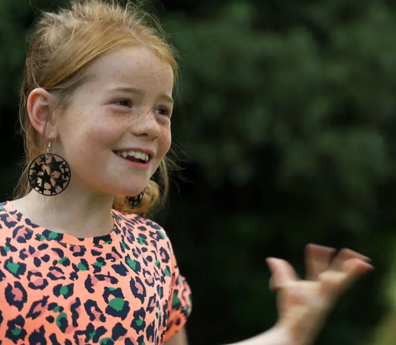 Kinderen zingen samen tijdens een zangles in de buitenlucht