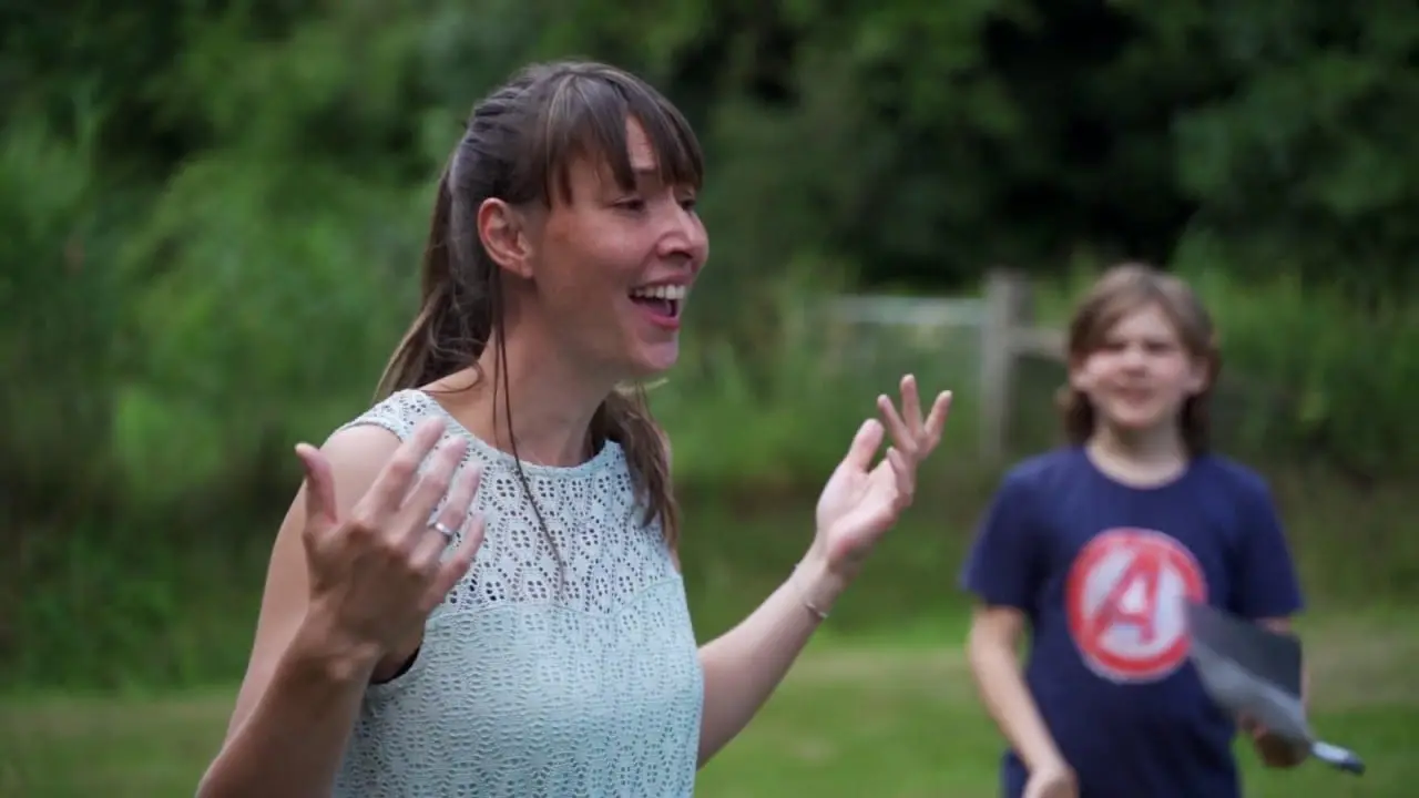 Theaterdocent Zora geeft buiten in het gras les aan een groep kinderen
